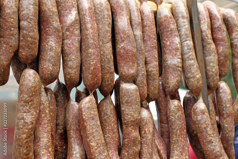 Sausages. Sausages hang outdoor for sale on a street market.Home made meat salami sausage at street market hanging in line under sunlight to make good tasty. sausages hang outdoor. Sausages. Sausages hang outdoor for sale on a street market.Home made meat salami sausage at street market hanging in line under sunlight to make good tasty. sausages hang outdoor.