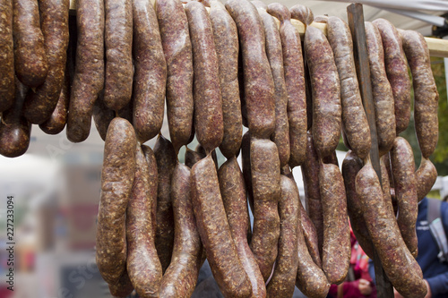 Sausages. Sausages hang outdoor for sale on a street market.Home made meat salami sausage at street market hanging in line under sunlight to make good tasty. sausages hang outdoor. 