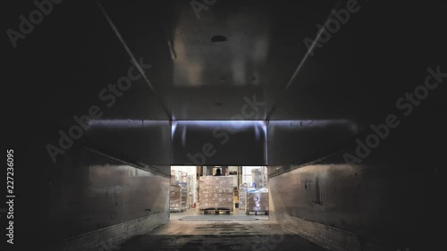 Forklift load boxes from dock into a truck. Logistics and cargo transportation.