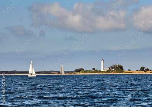 Keldsnor lighthouse and sailing yachts on a sunny day