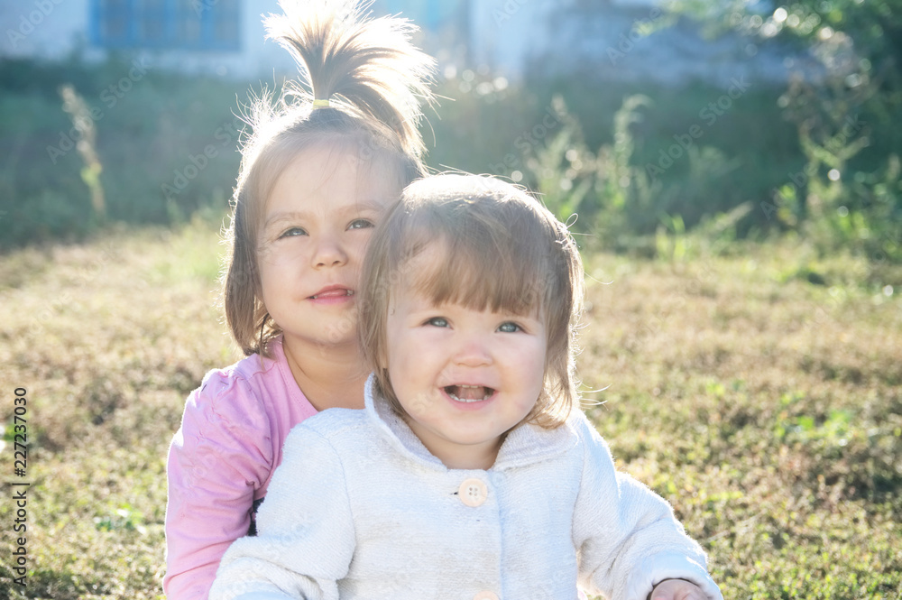 sisters portrait outdoors at sunny day. happy smiling sibling sisters portrait outdoors at sunny day. happy smiling sibling