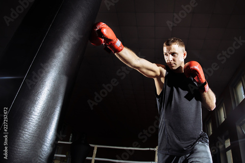 The man in boxing gloves. Boxing man ready to fight. Boxing, workout, muscle, strength, power - the concept of strength training and boxing