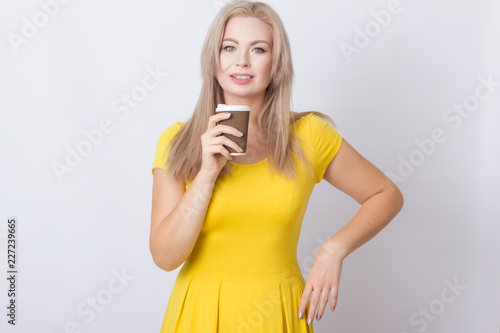 Blonde woman holding coffee cup in her hands
