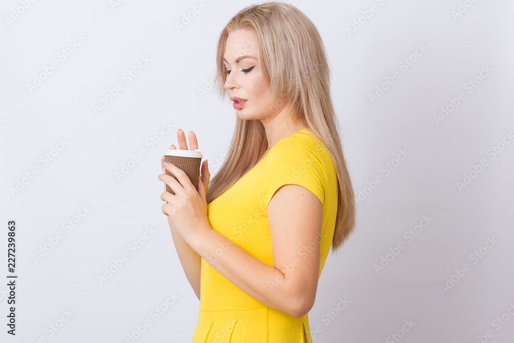 Blonde woman holding coffee cup in her hands Blonde woman holding coffee cup in her hands