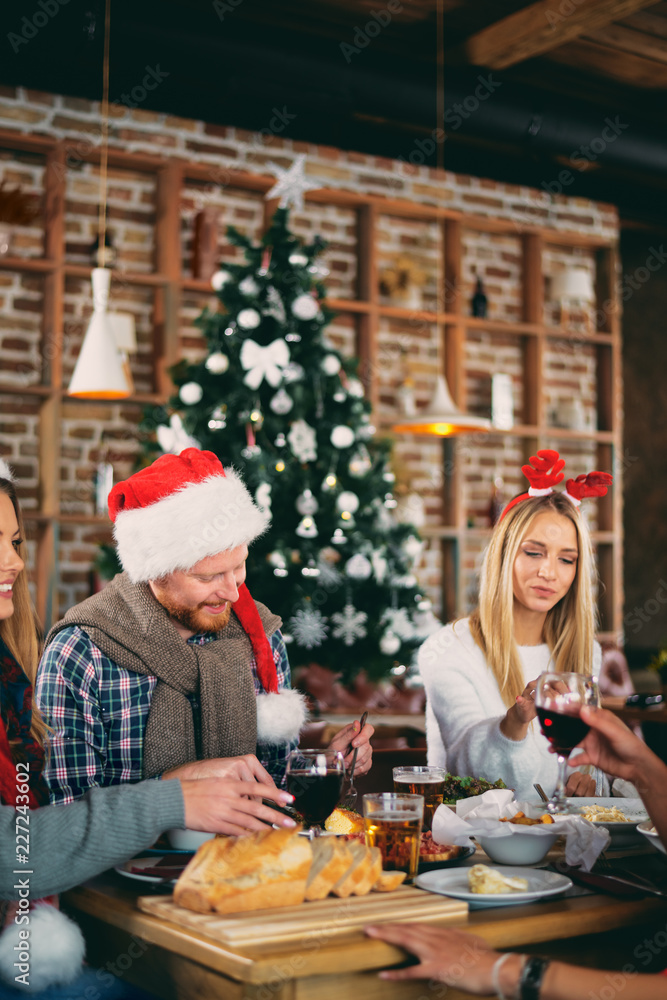 Friends having dinner at home at Christmas eve. Winter holidays concept. Friends having dinner at home at Christmas eve. Winter holidays concept.