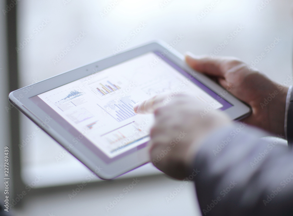 close up.businessman analyzing financial data using digital tablet close up.businessman analyzing financial data using digital tablet