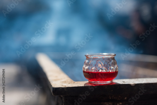 Red candle in a glass on an incense burner with smoke in Wenshu monastery, Chengdu, Sichuan Province, China photo