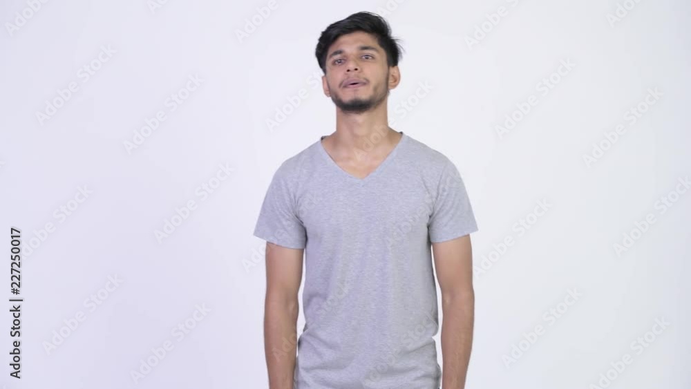 Young happy bearded Indian man thinking and waving hand Young happy bearded Indian man thinking and waving hand