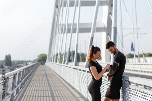 Young couple preparing for morning workout outdoors.