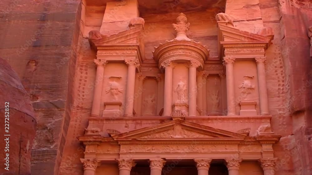 PETRA, JORDAN CIRCA 2016 - Low angle view of the facade of the Treasury building in the ancient Nabatean ruins of Petra, Jordan. PETRA, JORDAN CIRCA 2016 - Low angle view of the facade of the Treasury building in the ancient Nabatean ruins of Petra, Jordan.