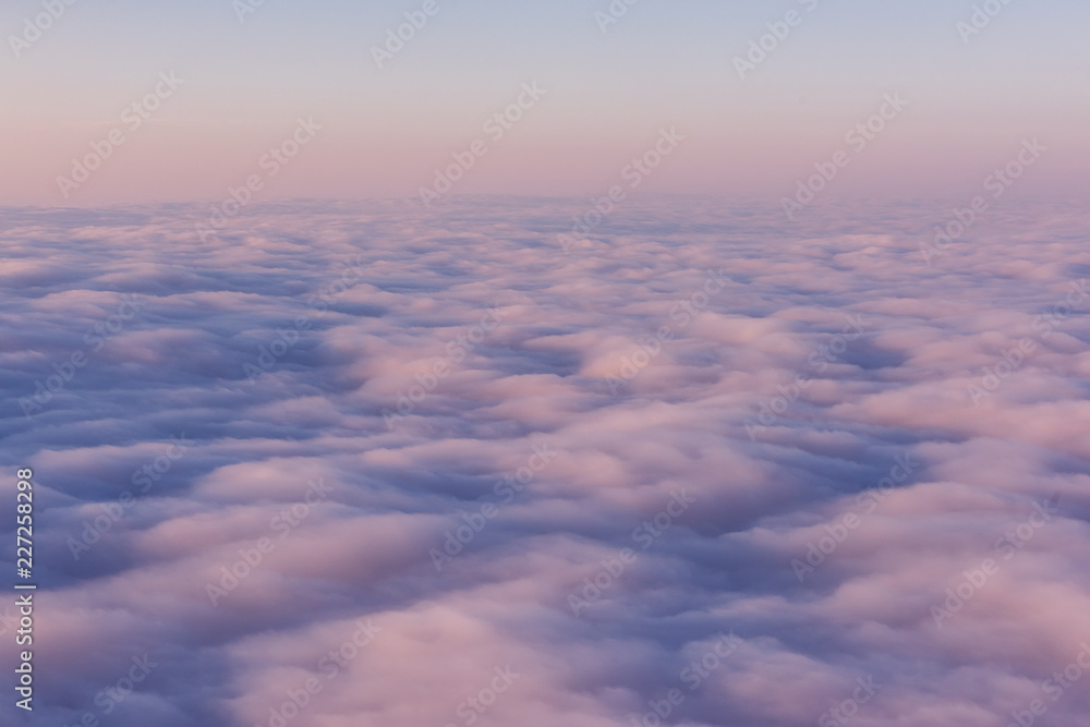 A field of pink clouds at sunset. View from above. Sky feather beds.
