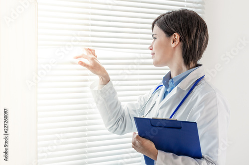 Young doctor or nurse looking through a window