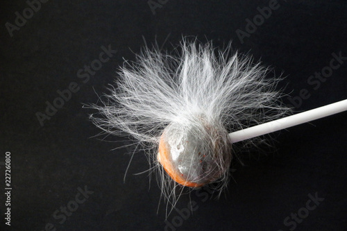 fluffy lollipop. Caramel in white woolly wool on a black background. dirty candy