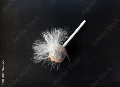 fluffy lollipop. Caramel in white woolly wool on a black background. dirty candy