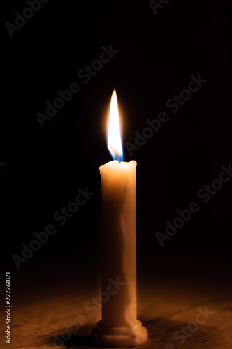 A table lit by a candle in a dark room