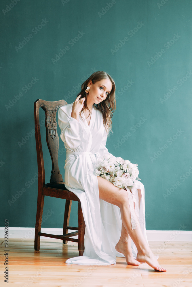 Conceptual wedding, the morning of the bride in the European style. Boudoir dress and a bouquet of flowers, fees in the interior Studio. Conceptual wedding, the morning of the bride in the European style. Boudoir dress and a bouquet of flowers, fees in the interior Studio.