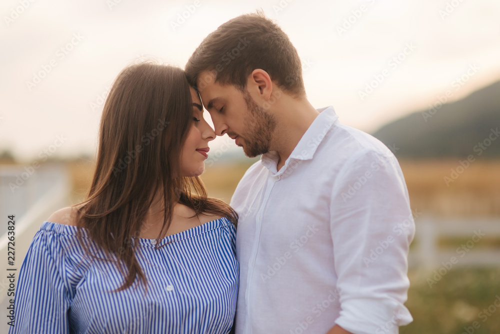 Man kisses a woman in nature. Romantic atmosphere Man kisses a woman in nature. Romantic atmosphere