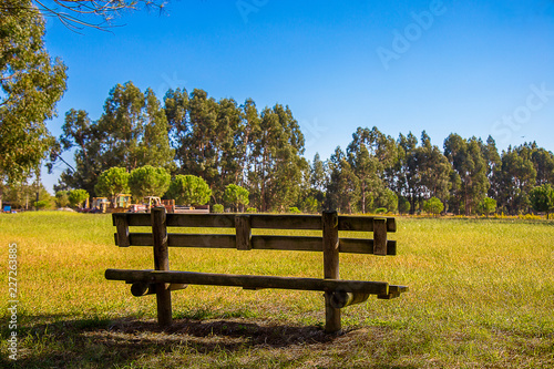 Wooden Bench in the Country, under a Blue Sky