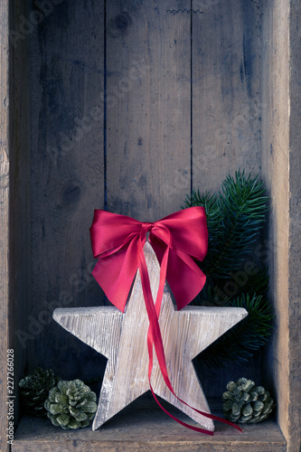 Christmas decoration red ribbon on a star in a wooden box background photo