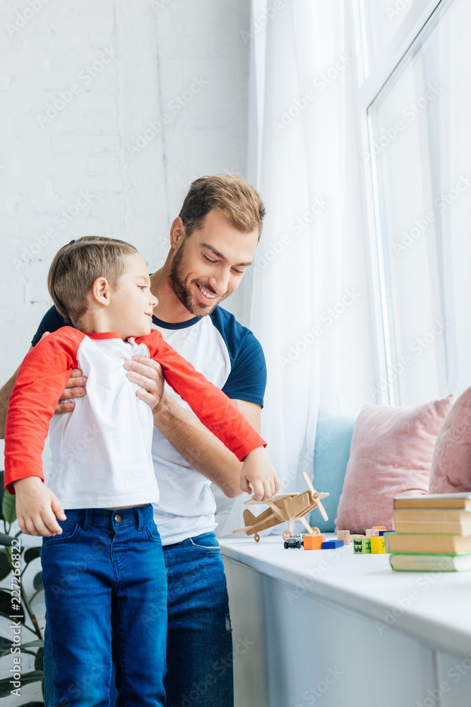 Fototapeta premium portrait of smiling father holding little son at home