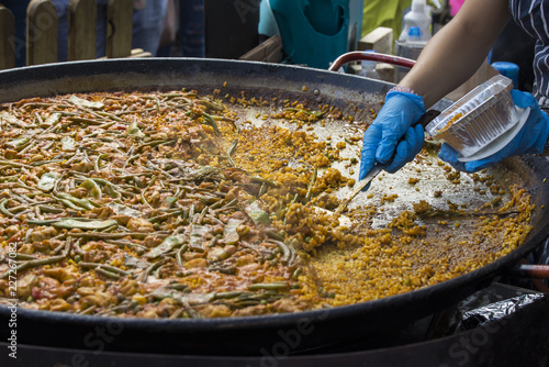 Street food: cooking and serving paella, traditional spanish rice dish