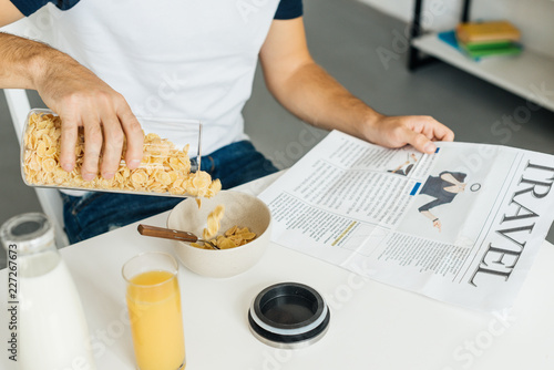 partial view of man having breakfast in kitchen at home