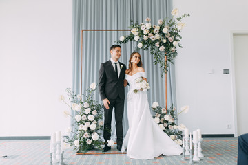 Stylish European wedding ceremony. The bride and groom are surrounded by guests. Arch and decor of fresh flowers. .Wedding ideas