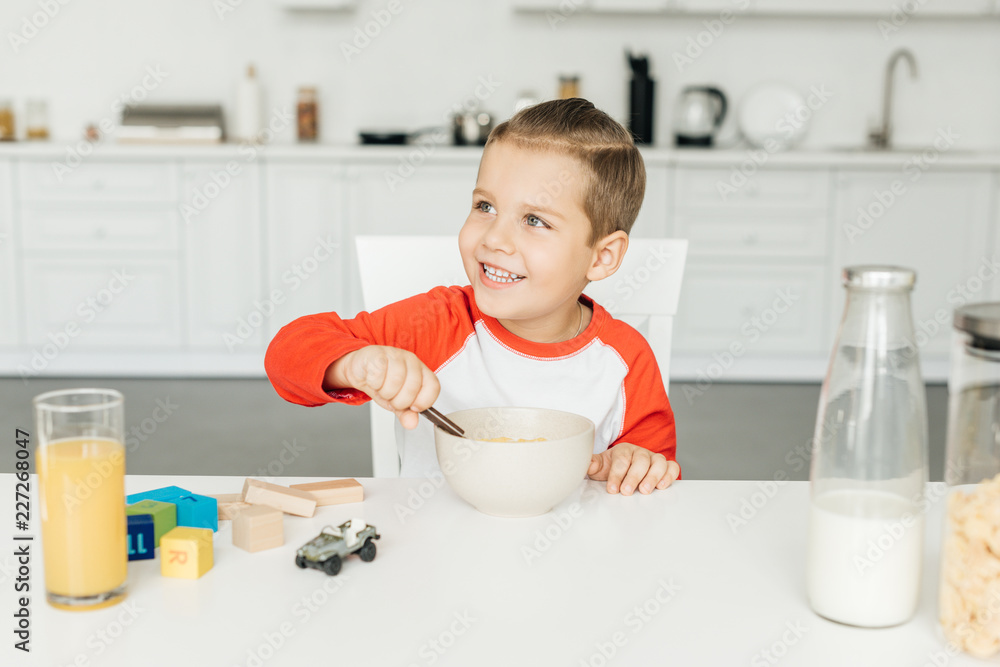 portrait of little smiling boy having breakfast in kitchen at home portrait of little smiling boy having breakfast in kitchen at home