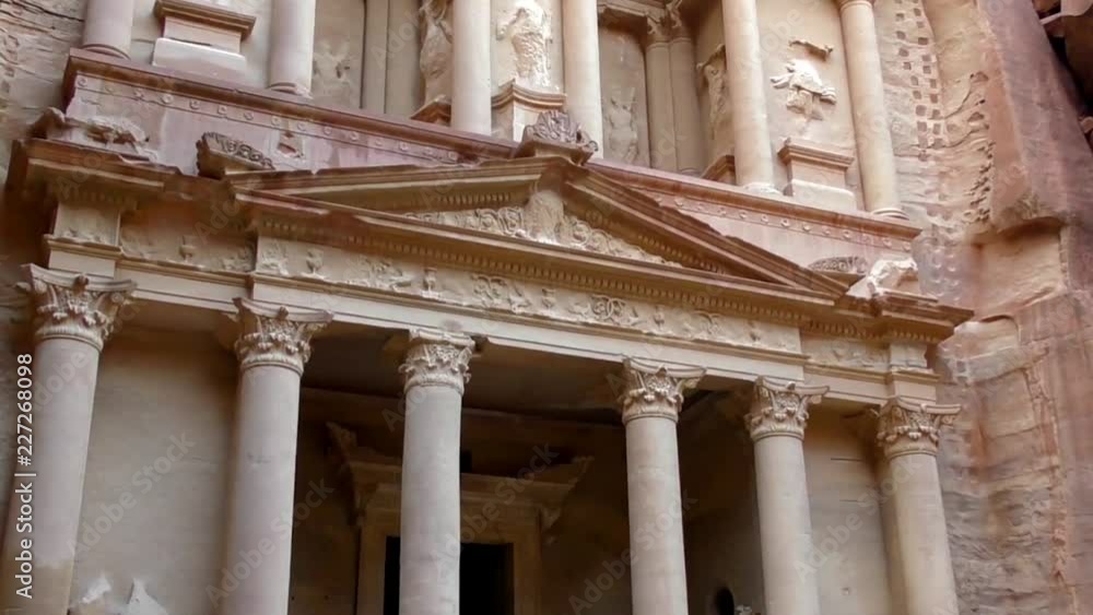 PETRA, JORDAN CIRCA 2016 - Low angle view of the facade of the Treasury building in the ancient Nabatean ruins of Petra, Jordan. PETRA, JORDAN CIRCA 2016 - Low angle view of the facade of the Treasury building in the ancient Nabatean ruins of Petra, Jordan.