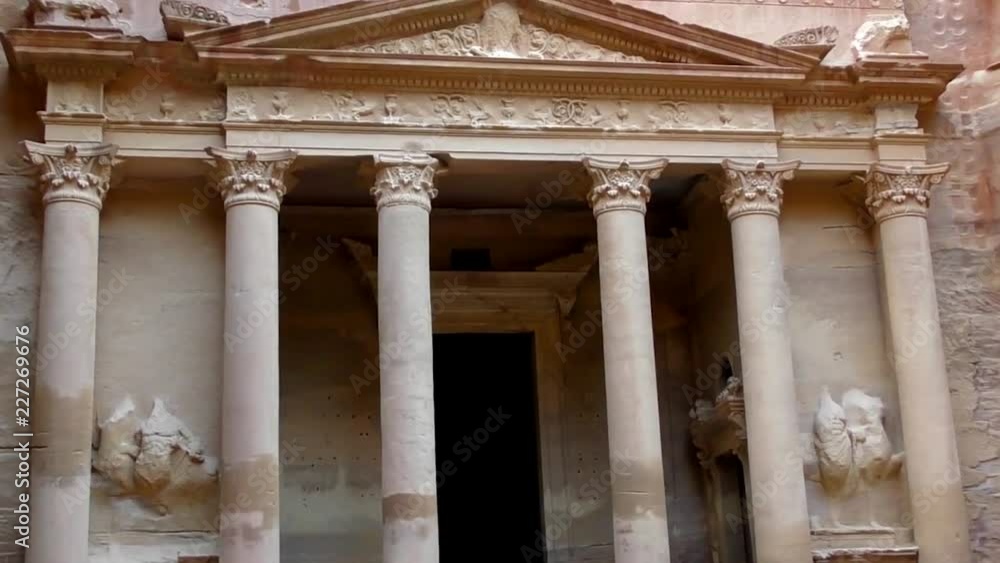 PETRA, JORDAN CIRCA 2016 - Low angle view of the facade of the Treasury building in the ancient Nabatean ruins of Petra, Jordan. PETRA, JORDAN CIRCA 2016 - Low angle view of the facade of the Treasury building in the ancient Nabatean ruins of Petra, Jordan.