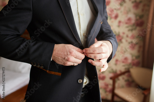 Hands of groom getting ready in suit