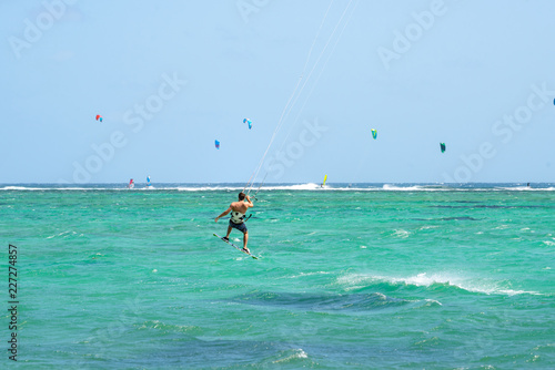 Kitesurfing kitesurfer near Mauritius beach and sea, waves in the water. Beautiful sea water Indian Ocean. Travel to Mauritius island a paradise island in Africa. Kite surfing.