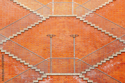 some symetrically stairways in front of a red brick wall photo