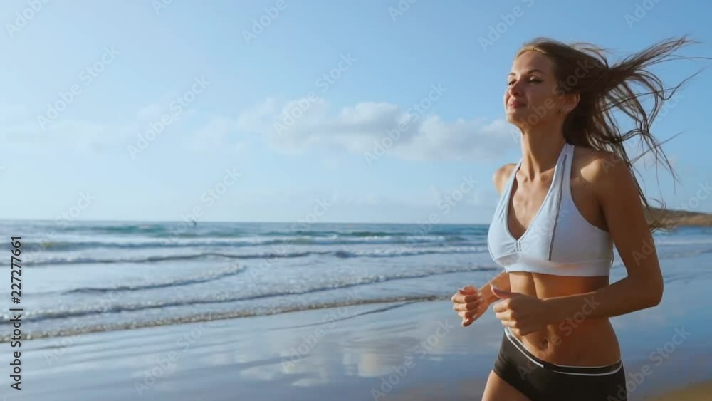 woman athlete silhouette running on beach sprinting waves crashing on seaside morning background. SLOW MOTION STEADICAM. woman athlete silhouette running on beach sprinting waves crashing on seaside morning background. SLOW MOTION STEADICAM.