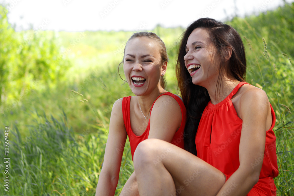 Young girls in red dresses laugh a lot Young girls in red dresses laugh a lot