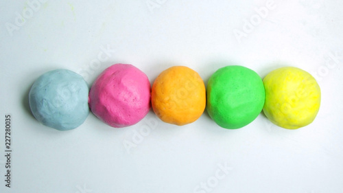 Close up of homemade colorful playdough on a white table.