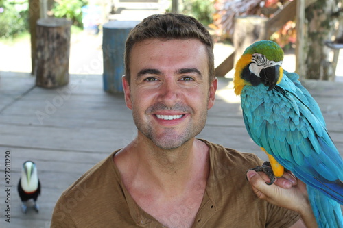 Handsome man holding a macaw