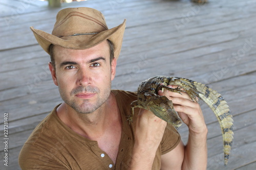 Handsome man holding a caiman 