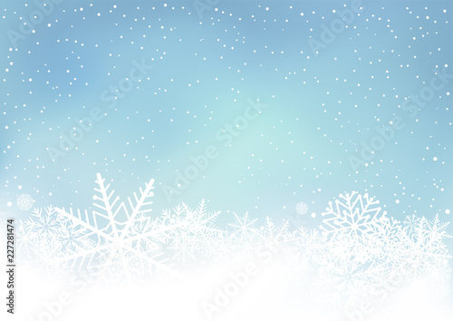 Winter blue sky background with snow. Frosty close-up wintry snowflakes. Ice shape pattern. Christmas holiday decoration backdrop