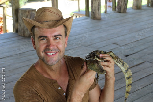 Human interacting with a baby caiman 