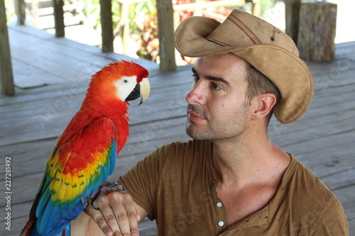Handsome man holding a macaw 
