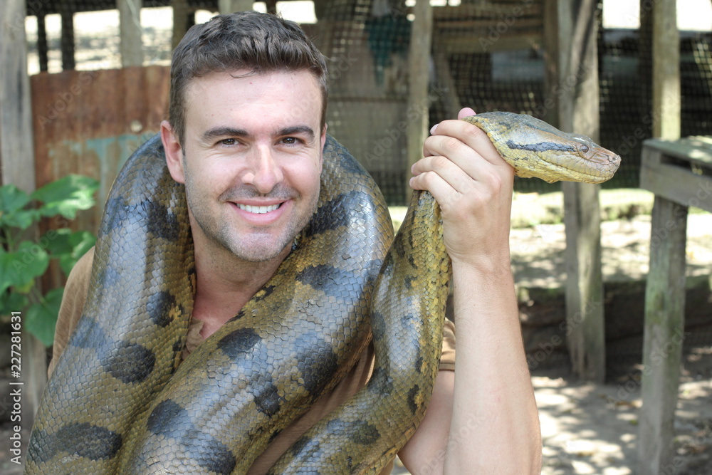 Obraz premium Man with a giant Anaconda around his neck