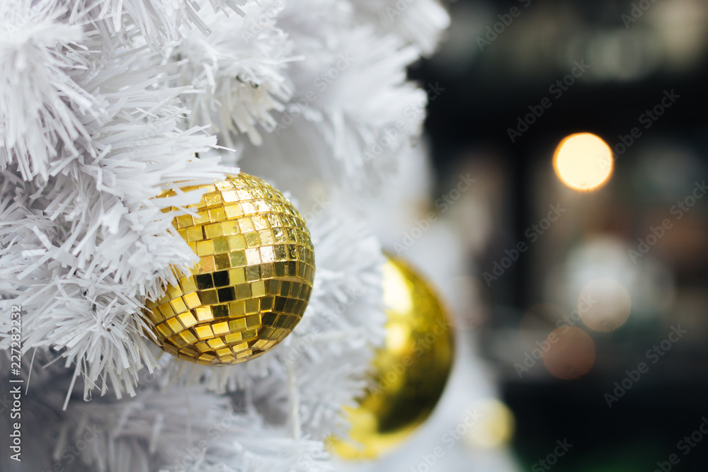 Fototapeta premium Golden christmas ball on white christmas tree