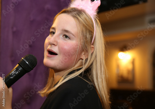 Beautiful blonde girl singing into a microphone © Irina Tarzian