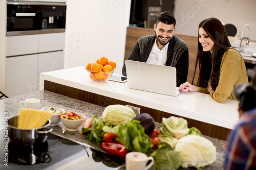Couple looking at laptop in modern kitchen