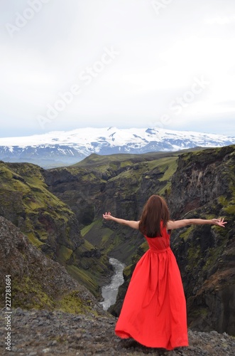 woman in mountains red dress trekking iceland canyon