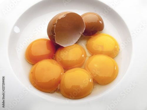 Varios huevos rotos dentro de un plato redondo blanco  2