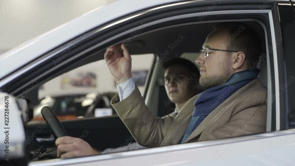 Young man sitting in car. Auto business, car sale, technology and people concept Young man sitting in car. Auto business, car sale, technology and people concept