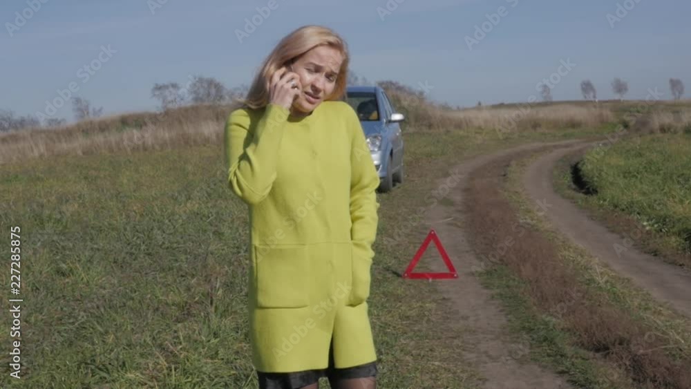 charming business woman calls for help by mobile phone. girl near broken car on rural road. slow motion charming business woman calls for help by mobile phone. girl near broken car on rural road. slow motion