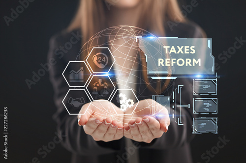 The concept of business, technology, the Internet and the network. A young entrepreneur working on a virtual screen of the future and sees the inscription: taxes reform